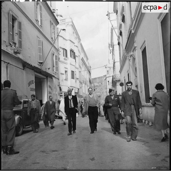 Monsieur Lasky accompagné de monsieur Marce, du gouvernement général, et du capitaine Servan dans une rue de la casbah.