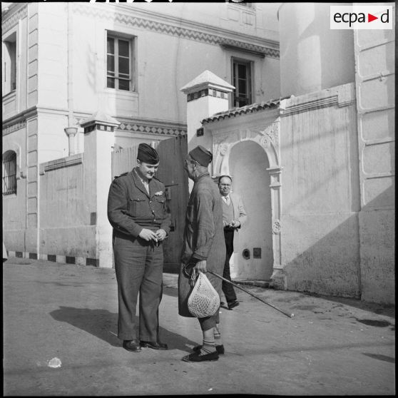 Le capitaine Servan en conversation avec un homme.