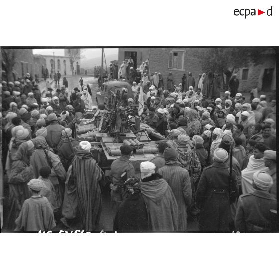 Présentation à la population d'Arris de l'armement et des trois drapeaux pris aux rebelles.