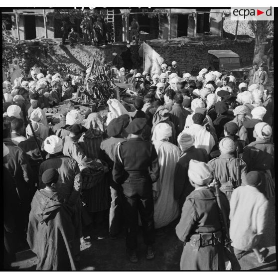 Présentation à la population d'Arris de l'armement et des trois drapeaux pris aux rebelles.