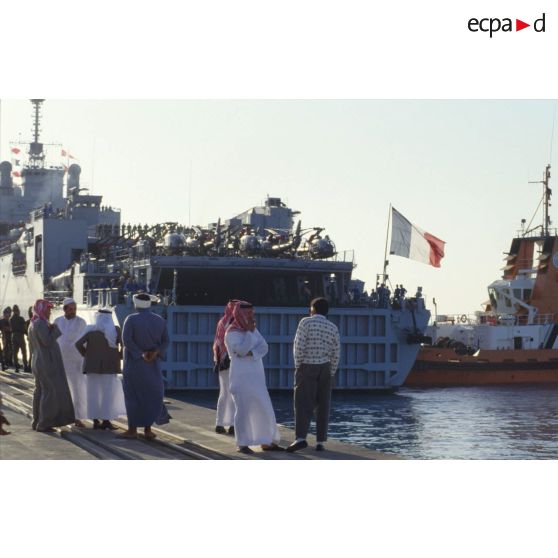 Le TCD (transport de chalands de débarquement) Foudre arrive à quai à Yanbu. La population civile suit les manoeuvres du pousseur.