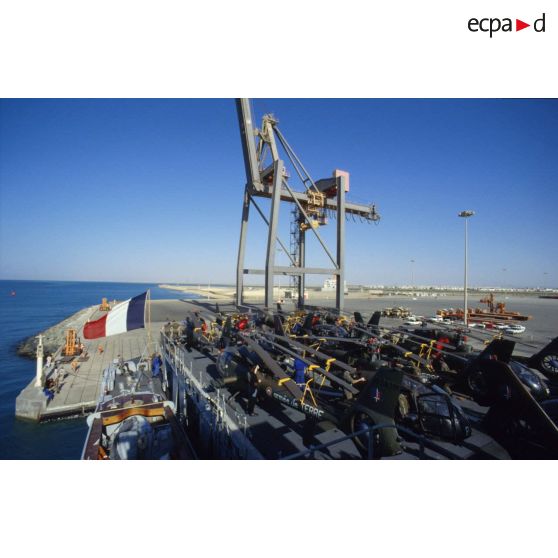 Sur la plage arrière du TCD (transport de chalands de débarquement) Foudre à quai à Yanbu sont alignés des hélicoptères de combat Gazelle de l'ALAT (aviation légère de l'armée de terre), pales repliées.