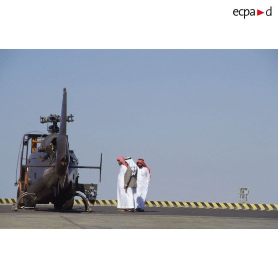Un groupe de Saoudiens examine un hélicoptère de combat Gazelle de l'ALAT (aviation légère de l'armée de terre) aux pales démontées déchargé sur un quai du port de Yanbu.
