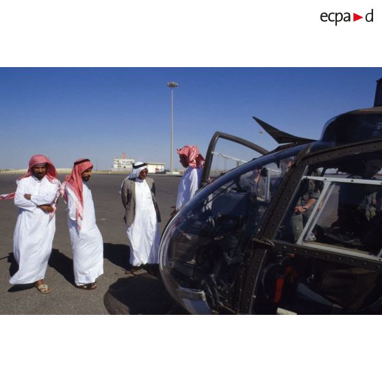 Un groupe de Saoudiens examine un hélicoptère de combat Gazelle de l'ALAT (aviation légère de l'armée de terre) déchargé sur un quai du port de Yanbu.