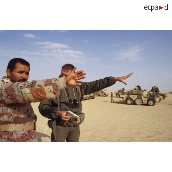 Un soldat demande sa route dans le désert à un militaire saoudien, à l'aide d'un dictionnaire, pour la colonne de blindés de reconnaissance ERC-90 Sagaie du 1er RHP (régiment de hussards parachutistes).