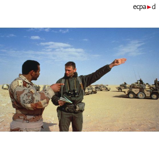 Un soldat demande sa route dans le désert à un militaire saoudien, à l'aide d'un dictionnaire, pour la colonne de blindés de reconnaissance ERC-90 Sagaie du 1er RHP (régiment de hussards parachutistes).