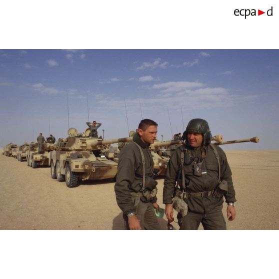 Deux soldats se concertent sur la route à prendre dans le désert d'après les renseignements fournis par des militaires saoudiens à l'aide d'un dictionnaire, pour la colonne de blindés de reconnaissance ERC-90 Sagaie du 1er RHP (régiment de hussards parachutistes).