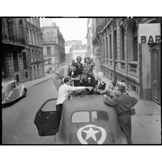 Fraternisation entre civils et militaires à l'annonce de la victoire des Alliés sur l'Allemagne.