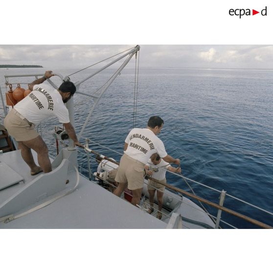 Embarquement du pneumatique de la gendarmerie maritime à bord de la vedette P778. [Description en cours]