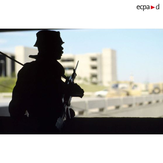 Silhouette d'une sentinelle française, armée d'un fusil d'assaut FAMAS muni d'une baïonnette à CRK (camp du roi Khaled).
