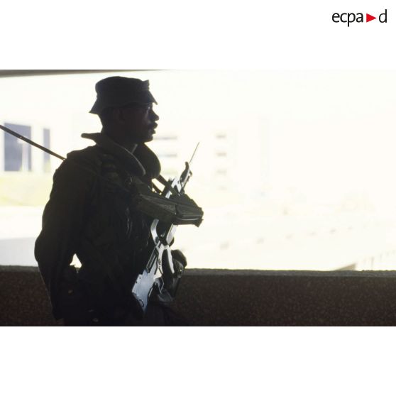 Silhouette d'une sentinelle française, armée d'un fusil d'assaut FAMAS muni d'une baïonnette à CRK (camp du roi Khaled).