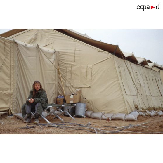 Un personnel féminin fume à l'entrée d'une tente du campement militaire de la base air américaine de CRK (camp du roi Khaled).