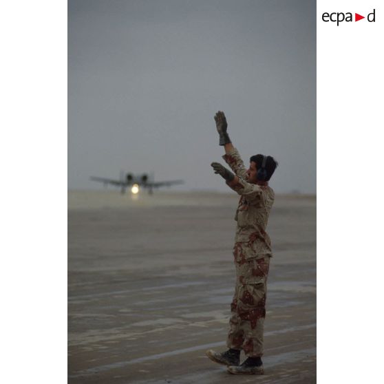 Un mécanicien de piste américain guide un avion d'appui rapproché Fairchild A-10 Thunderbolt-II au roulage sur la piste de la base air américaine de CRK (camp du roi Khaled).