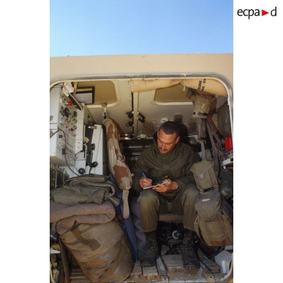 Un soldat au repos écrit son courrier à l'arrière d'un VAB du 11e RAMa (régiment d'artillerie de marine) pendant un exercice en ZDO (zone de déploiement opérationnel) Olive.