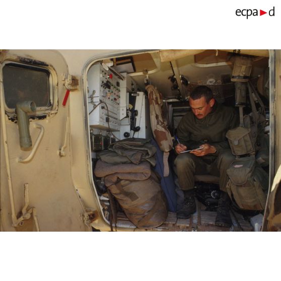 Un soldat au repos écrit son courrier à l'arrière d'un VAB du 11e RAMa (régiment d'artillerie de marine) pendant un exercice en ZDO (zone de déploiement opérationnel) Olive.
