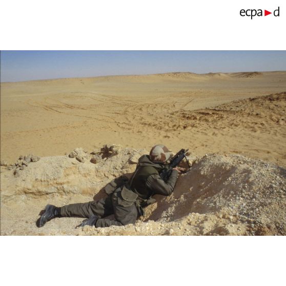 Soldat en position de tireur couché au FAMAS dans un trou de combat lors d'un exercice de tir du 11e RAMa (régiment d'artillerie de marine) en ZDO (zone de déploiement opérationnel) Olive.