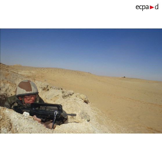 Soldat en position de tireur couché au FAMAS dans un trou de combat lors d'un exercice de tir du 11e RAMa (régiment d'artillerie de marine) en ZDO (zone de déploiement opérationnel) Olive.