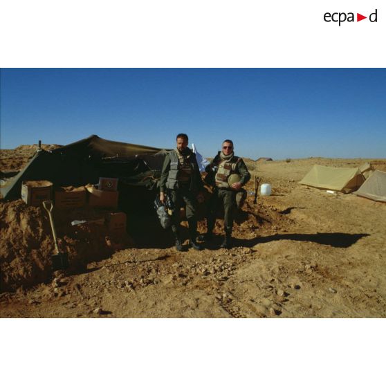 En ZDO (zone de déploiement opérationnel) Olive, le caméraman et le preneur de son de l'ECPA (Etablissement cinématographique et photographique des Armées) devant les tentes canadiennes, près de leur tente-abri.