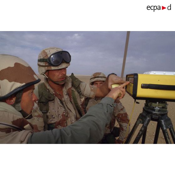 En ZDO (zone de déploiement opérationnel) Olive, un capitaine français géographe présente des instruments de mesure  topographiques à des militaires américains de la 101e Airborne.