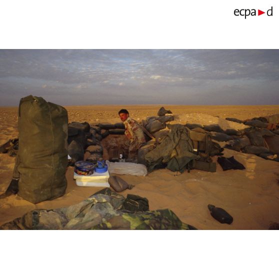 Un soldat américain dans son trou de survie, entouré de tout son équipement, aux alentours du CRK (camp du roi Khaled).