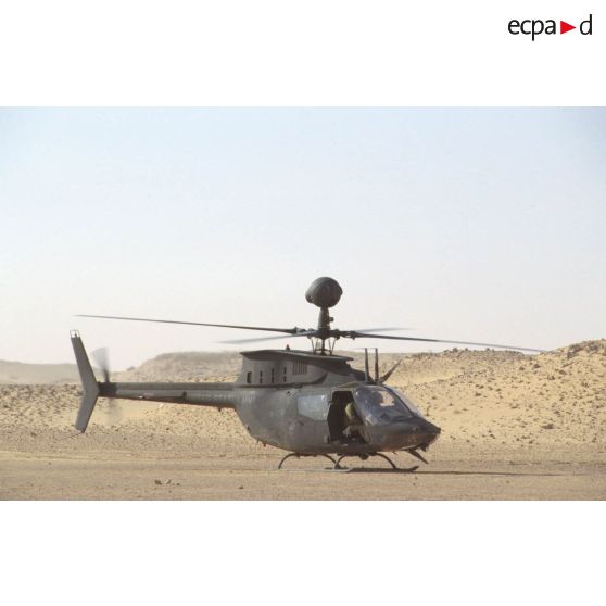 Aux alentours du CRK (camp du roi Khaled), un hélicoptère de reconnaissance et d'observation Bell-OH58 Kiowa muni d'un système de visée installé au-dessus du rotor au sol.