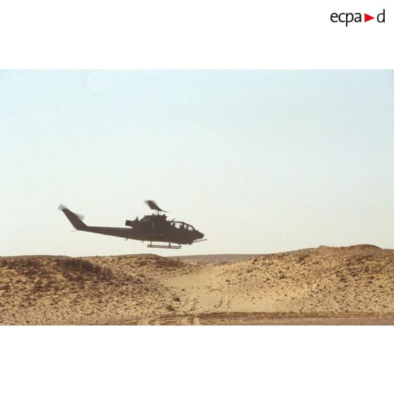 Aux alentours du CRK (camp du roi Khaled), un hélicoptère de lutte antichar Bell 209 Huey-Cobra en vol.