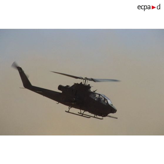 Aux alentours du CRK (camp du roi Khaled), un hélicoptère de lutte antichar Bell 209 Huey-Cobra en vol.