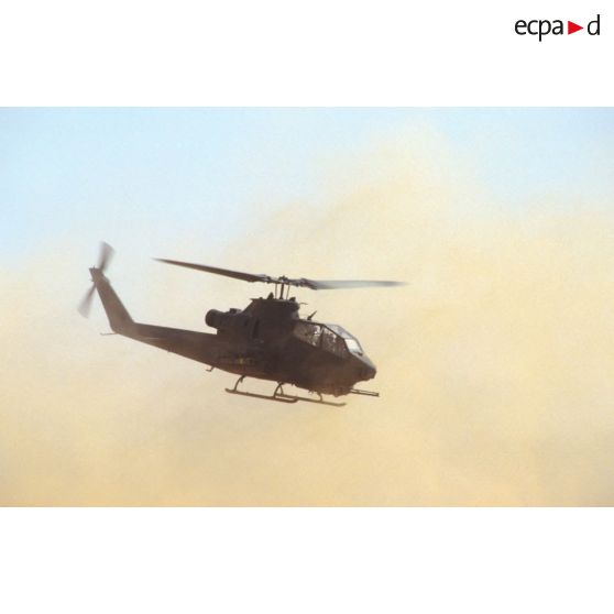 Aux alentours du CRK (camp du roi Khaled), un hélicoptère de lutte antichar Bell 209 Huey-Cobra en vol.