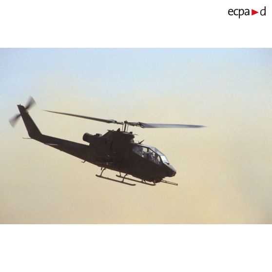 Aux alentours du CRK (camp du roi Khaled), un hélicoptère de lutte antichar Bell 209 Huey-Cobra en vol.