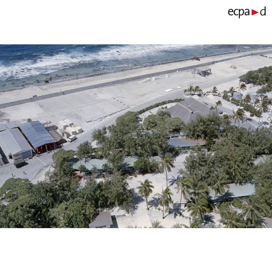 Vue aérienne de la zone vie au bord du lagon sur l’atoll de Moruroa. [Description en cours]