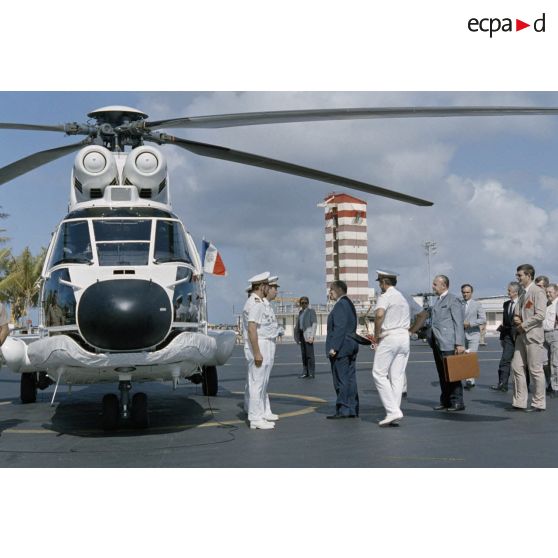 François Mitterrand, président de la République, embarque dans un Super Puma avec Charles Hernu, ministre de la Défense, pour un survol de Moruroa. [Description en cours]