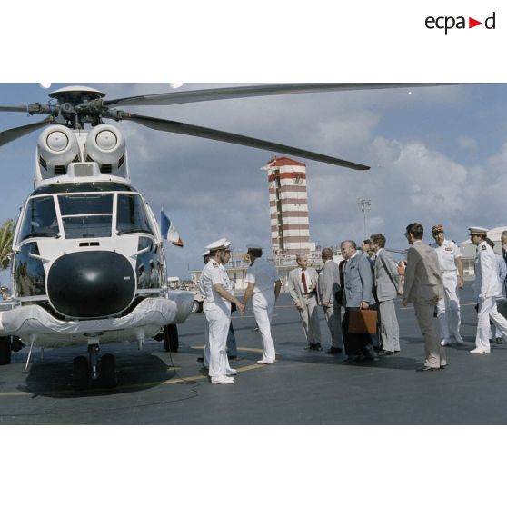 François Mitterrand, président de la République, embarque dans un Super Puma avec Charles Hernu, ministre de la Défense, pour un survol de Moruroa. [Description en cours]