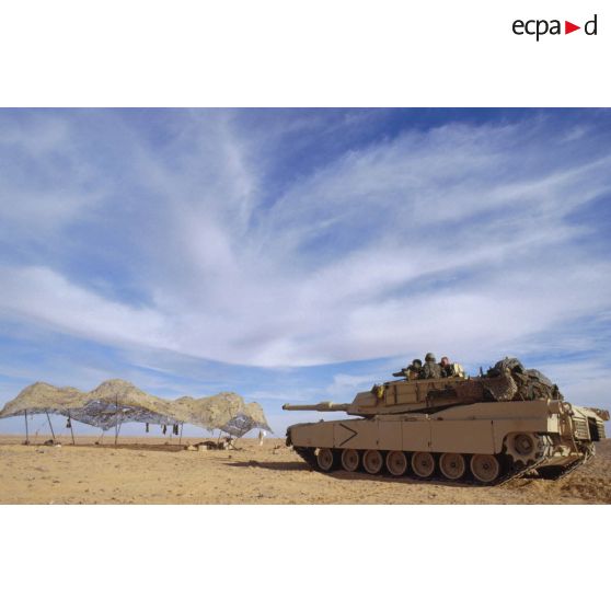 En ZDO (zone de déploiement opérationnel) Olive, char de combat Abrams-M1 américain dans le désert se dirige vers un filet de camouflage tendu.