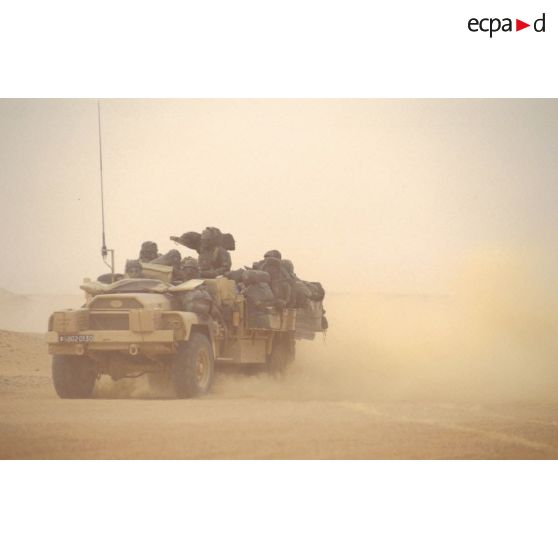 Dans le désert en ZDO (zone de déploiement opérationnel) Olive, des CRAP (commando de renseignement et d'action dans la profondeur) se déplacent à bord d'un VLRA (véhicule léger de reconnaissance et d'appui) débaché, avec des sacs à dos accrochés sur les flancs.