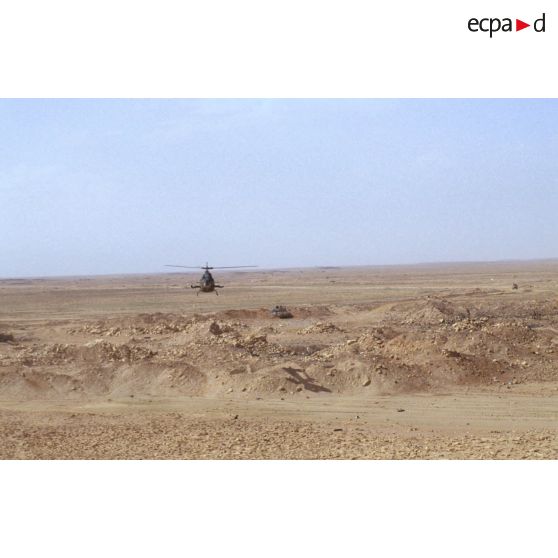 Survol par un hélicoptère Gazelle d'une position fortifiée irakienne et d'un char de combat T-55 détruits dans la zone de Rochambeau.