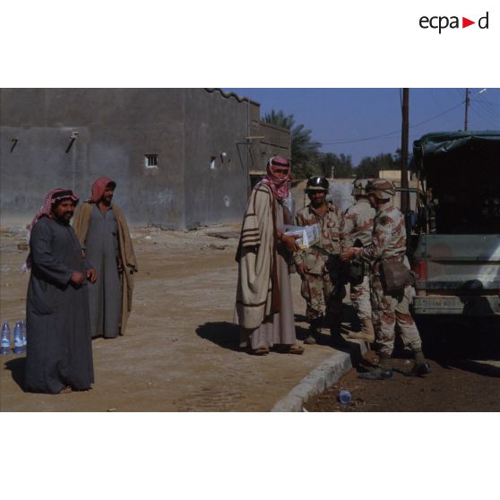Des soldats américains discutent avec des civils irakiens dans une rue d'Al Salman.