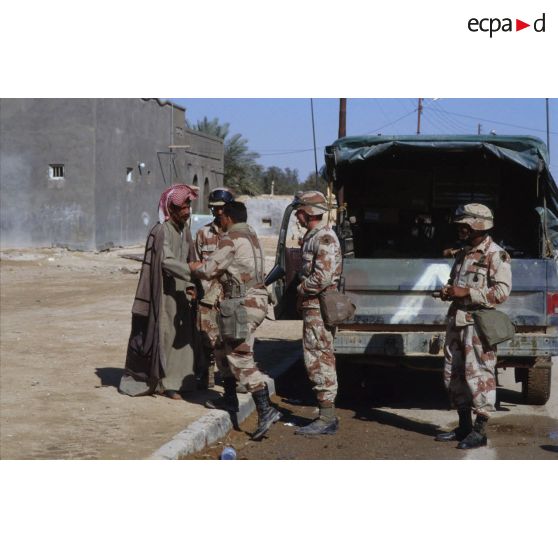 Des soldats américains discutent avec des civils irakiens dans une rue d'Al Salman.
