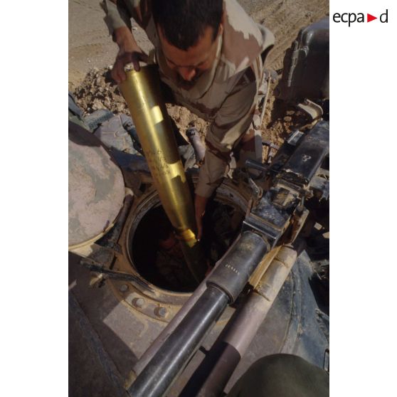 Un légionnaire du 6e REG (régiment étranger du génie) extrait un obus de la tourelle d'un char de combat T-55 irakien.