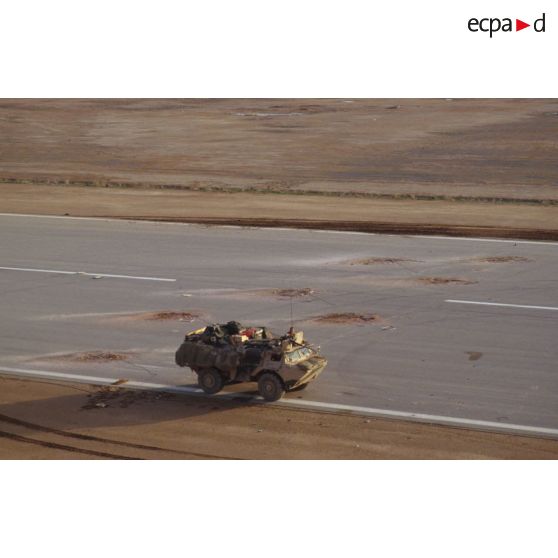 Vue aérienne d'un VAB du 6e REG (régiment étranger du génie) longeant la piste d'envol détruite de la base aérienne irakienne d'Al Salman.