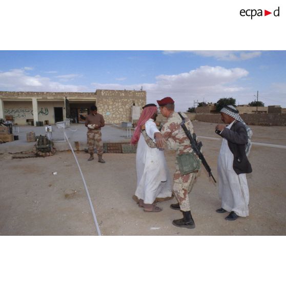 Un soldat américain des forces spéciales aux affaires civiles fouille un civil irakien dans une rue d'Al Salman.
