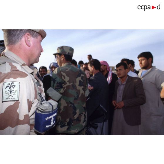 Des prévôts français et des soldats américains refoulent des réfugiés irakiens qui ne résident pas à Al Salman à l'entrée de la ville.