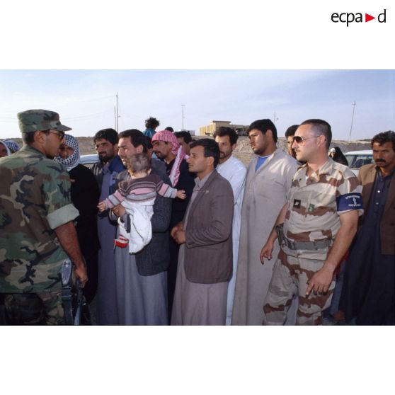 Des prévôts français et des soldats américains refoulent des réfugiés irakiens qui ne résident pas à Al Salman à l'entrée de la ville.