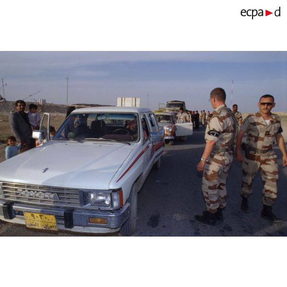 Des prévôts français et des soldats américains refoulent des réfugiés irakiens arrivant en voiture qui ne résident pas à Al Salman à l'entrée de la ville.