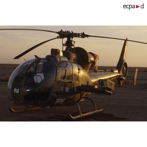 Le soir, un hélicoptère de combat Gazelle au sol dans le désert.