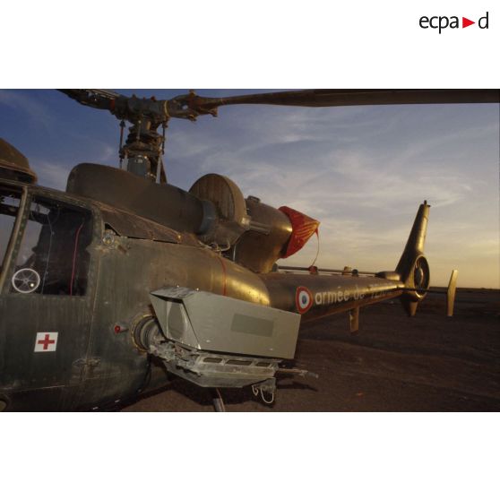 Le soir, un hélicoptère de combat Gazelle au sol dans le désert.