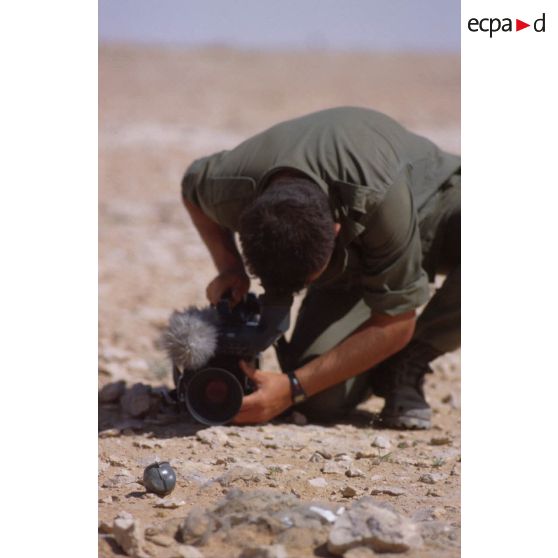 Sur le bord de l'Euphrate, le brigadier caméraman de l'ECPA (Etablissement cinématographique et photographique des Armées), caméra à terre, effectue un gros plan.