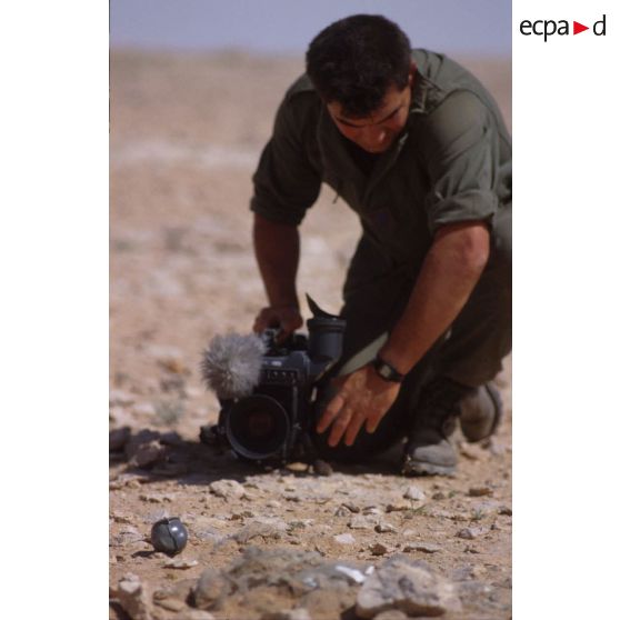 Sur le bord de l'Euphrate, le brigadier caméraman de l'ECPA (Etablissement cinématographique et photographique des Armées), caméra à terre, effectue un gros plan.