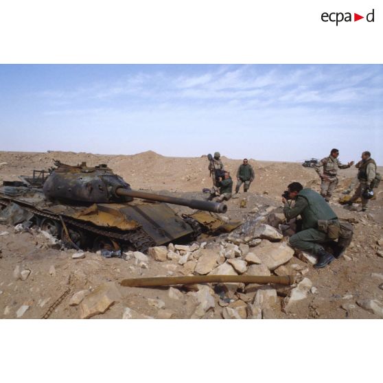 Une équipe de tournage et un photographe de l'ECPA (Etablissement cinématographique et photographique des Armées) ont pour sujet un char de combat T-55 irakien détruit.