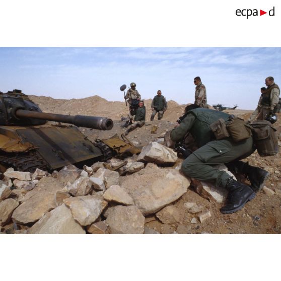 Une équipe de tournage et un photographe de l'ECPA (Etablissement cinématographique et photographique des Armées) ont pour sujet un char de combat T-55 irakien détruit.