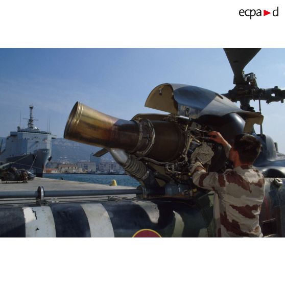 Au port de Toulon, un mécanicien du 3e RHC (régiment d'hélicoptères de combat) s'affaire sur la turbine d'un hélicoptère de combat Gazelle déchargé du TCD (transport de chalands de débarquement) Foudre amarré au quai.